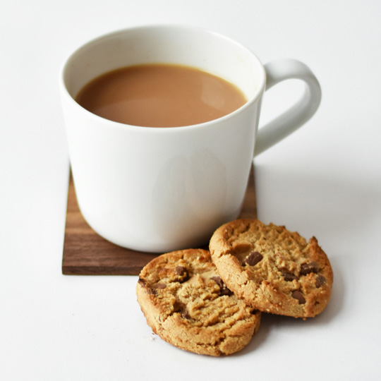 Picture of a cup of tea with two chocolate chip biscuits